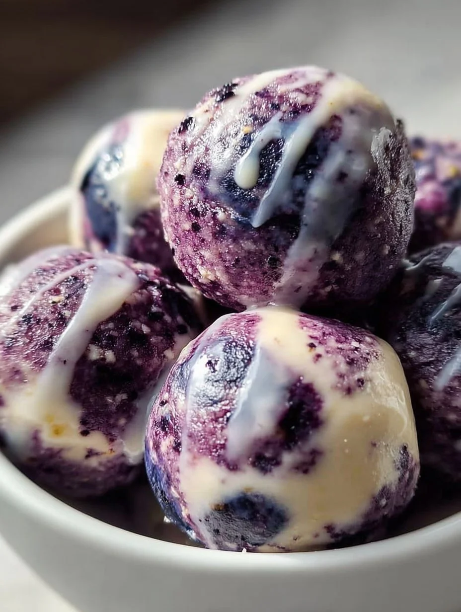 Blueberry Cheesecake Protein Bites on a plate garnished with fresh blueberries