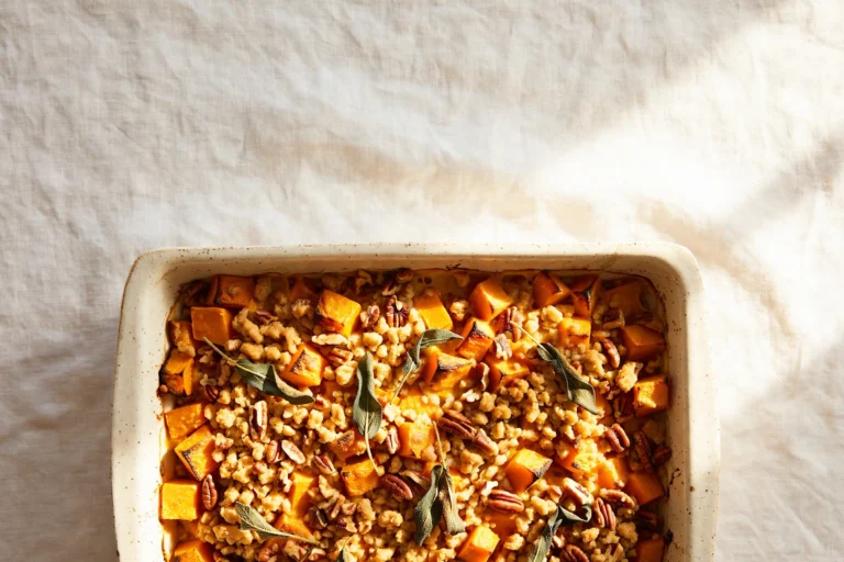 Butternut squash casserole with brown butter sage and a crisp pecan crumb in a white baking dish